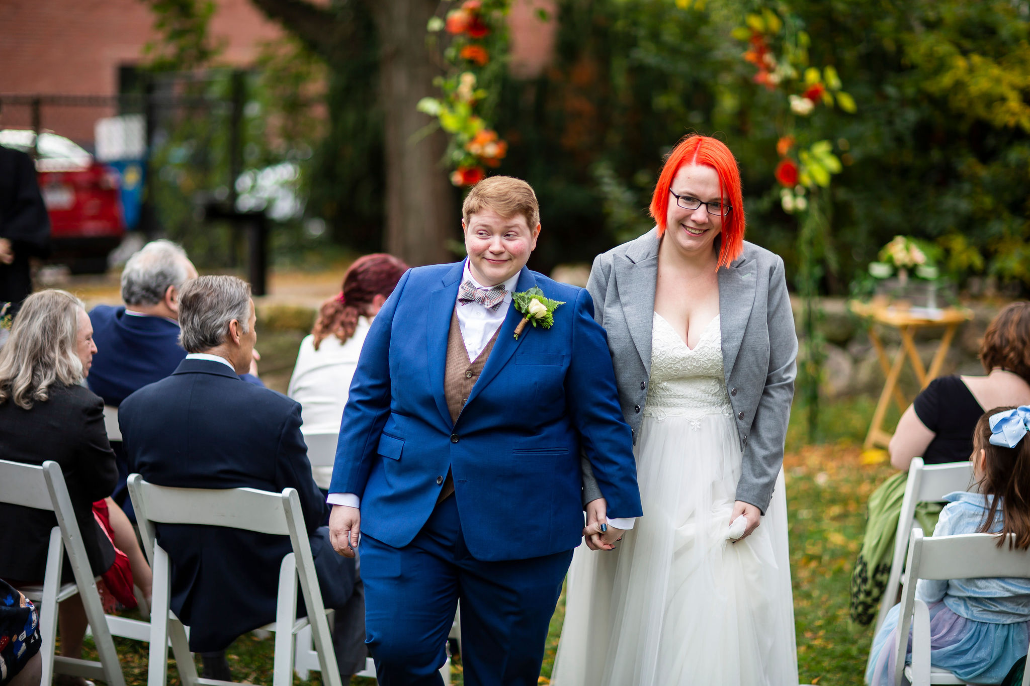 Mel & I walk hand-in-hand after the outdoor ceremony, smiling at family and friends.