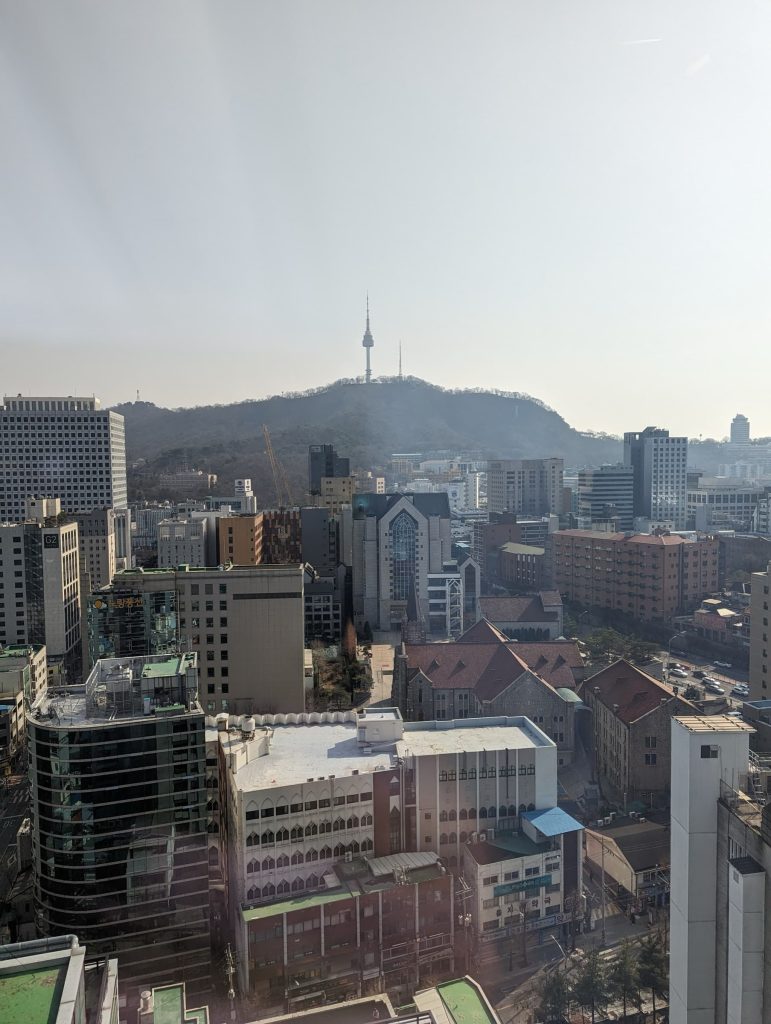 Landscape view with buildings in the foreground, and in the distance is Namsam Seoul Tower.