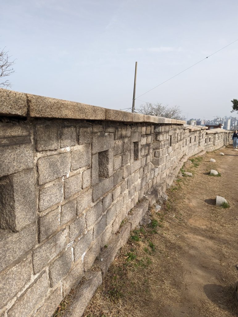 An old cobblestone wall, about 5ft tall, with a path alongside.