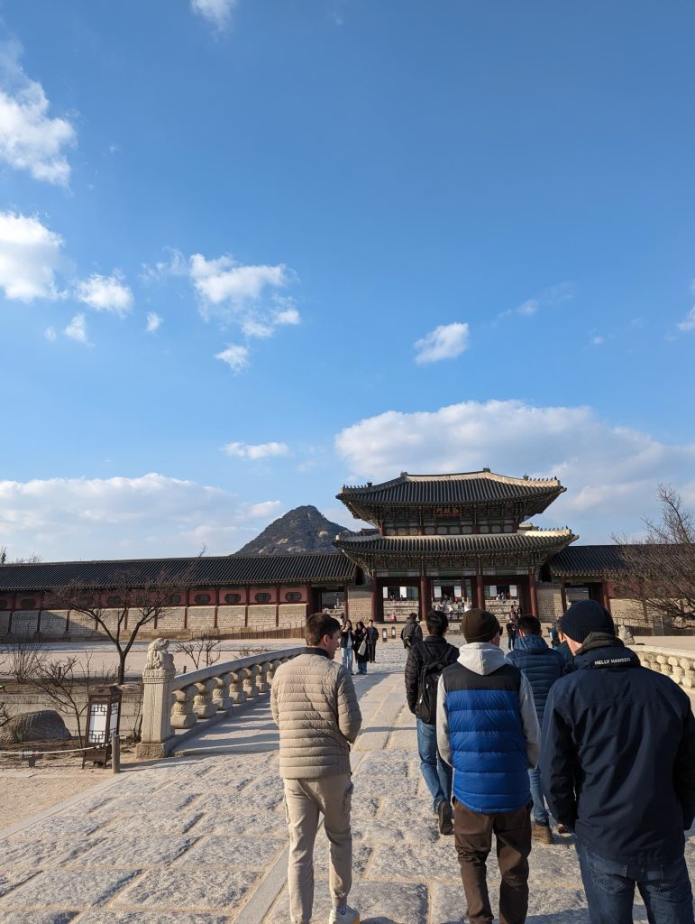 Gyeongbokgung palace in the background, the backs of 3 of my teammates walking towards it.