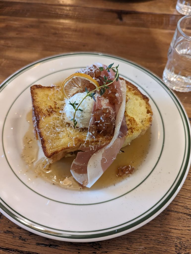 A plate of french toast with prosciutto and whipped ricotta.