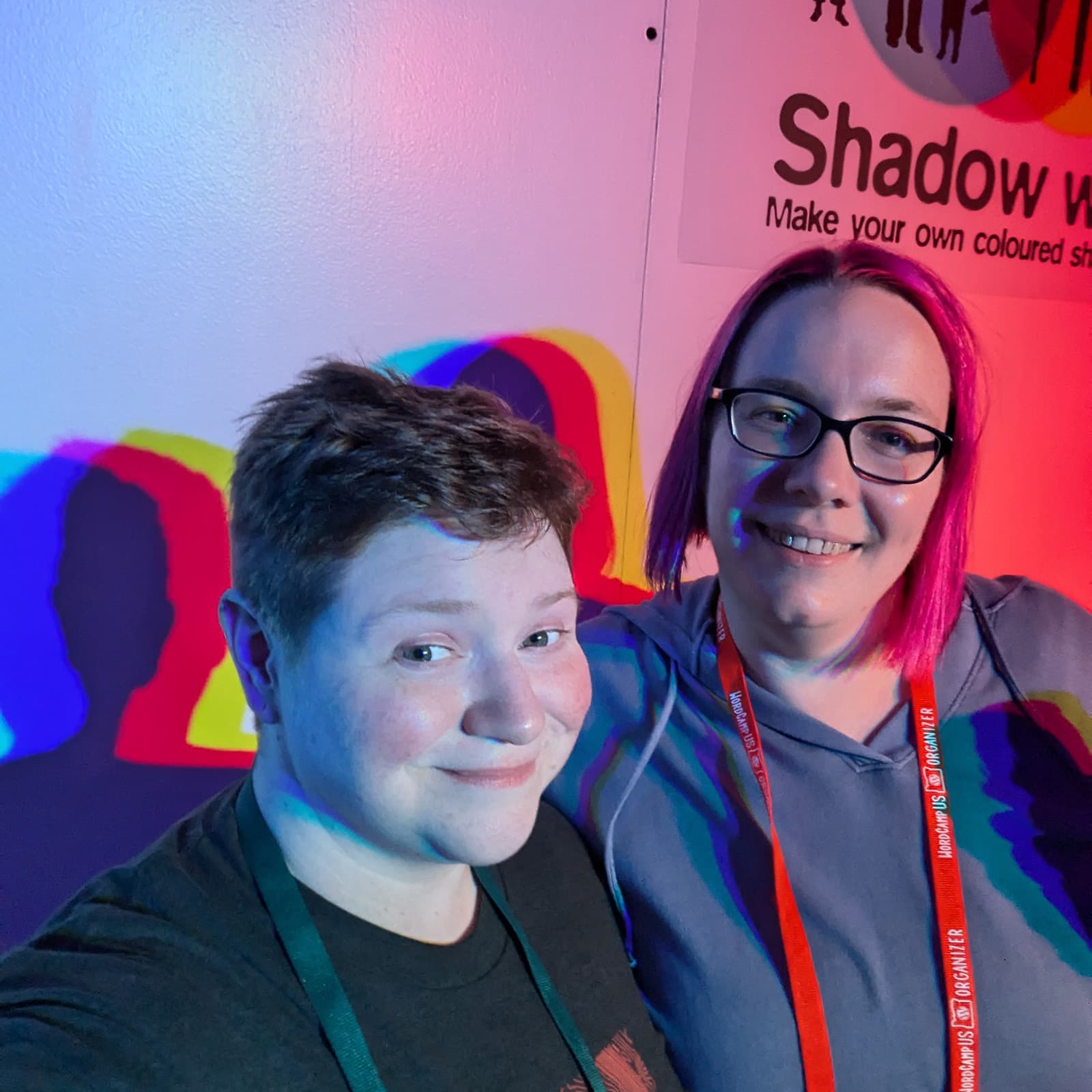 Mel & I in front of a science exhibit on light, which is casting shadows in different colors behind us.
