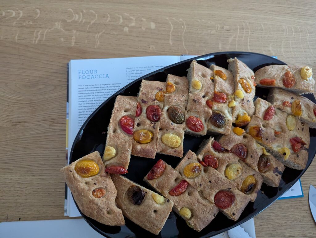 A plate of sliced focaccia topped with halved cherry tomatoes.